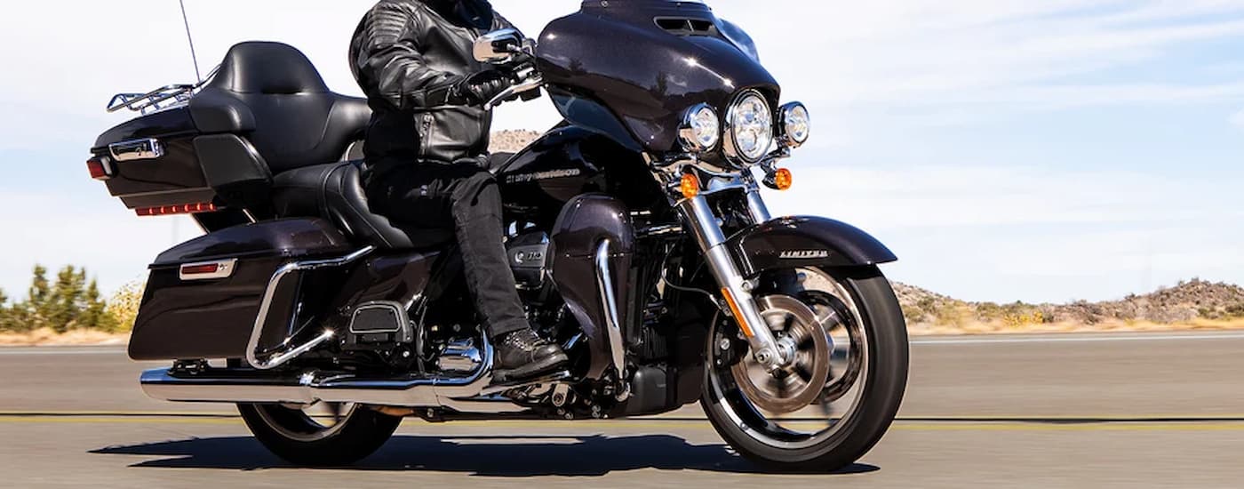 A black 2022 Harley-Davidson Ultra Limited is shown driving on an open road.