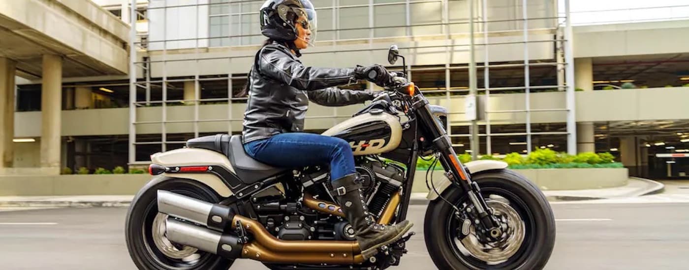 A grey 2022 Harley-Davidson  Fat Bob 114 is shown from the side on a city street after leaving a …
