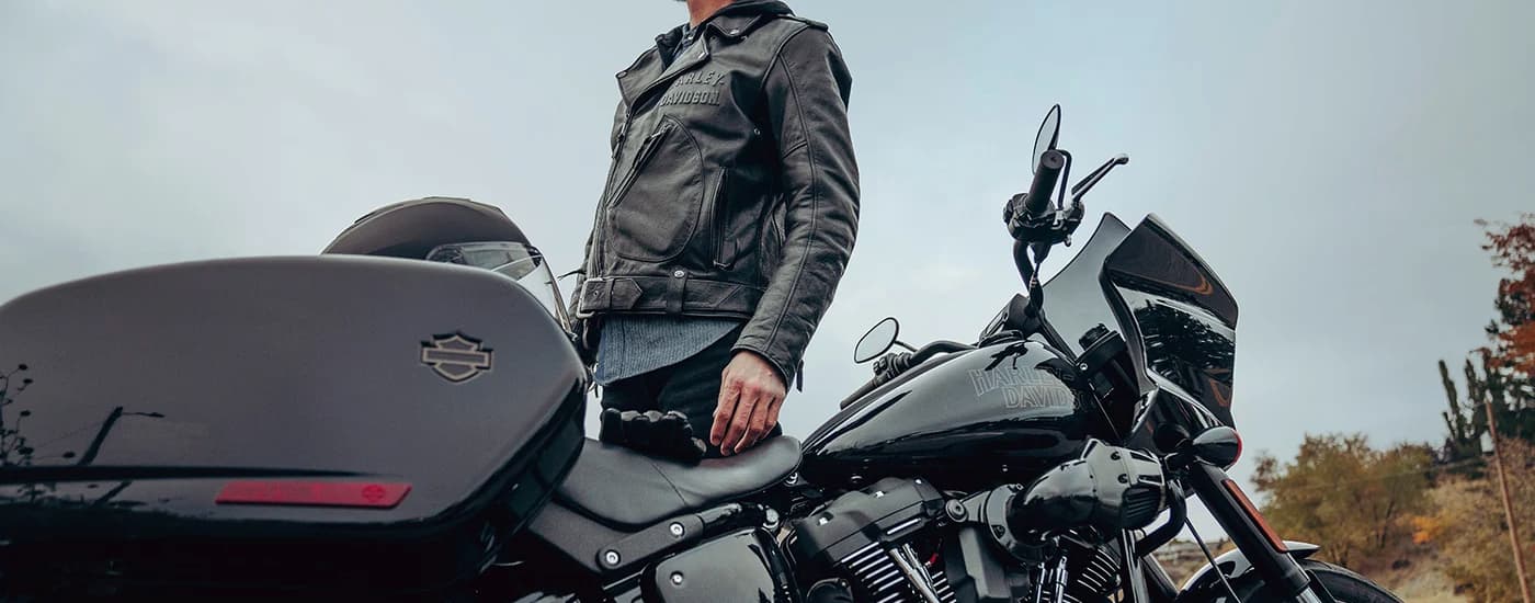 A man is shown standing next to a black 2023 Harley-Davidson Low Rider ST.