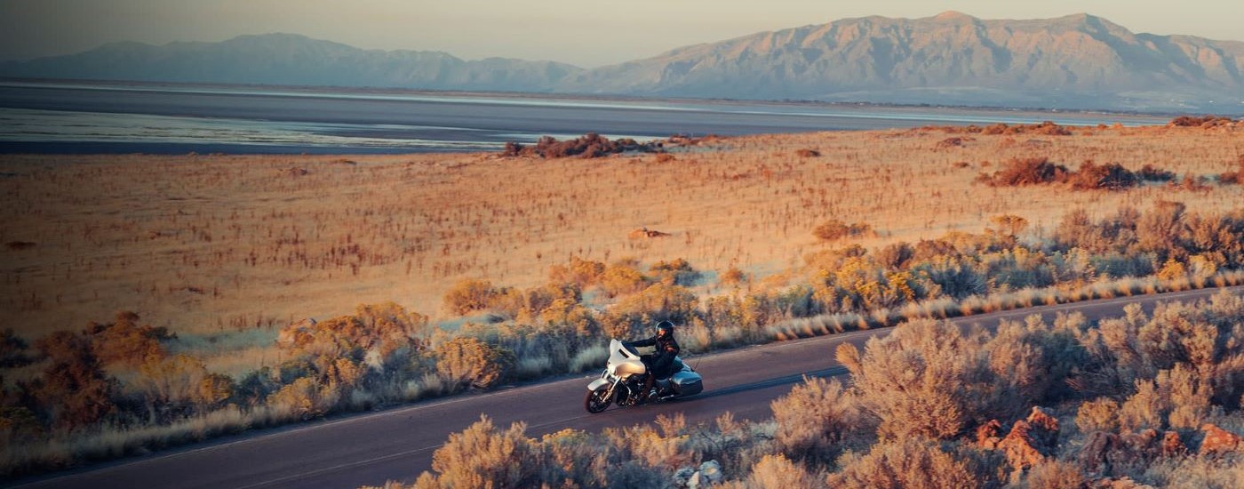 A silver 2023 Harley-Davidson Street Glide for sale is shown driving on an open road.