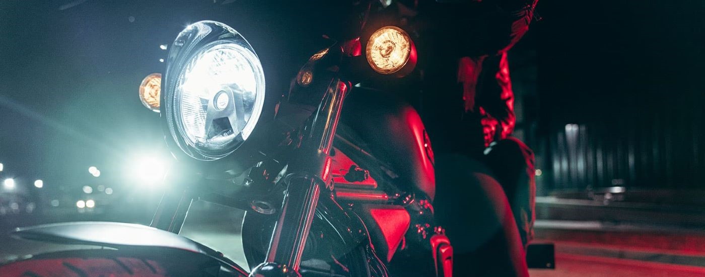 A close up shows the headlight on a black 2023 Harley-Davidson Nightster.