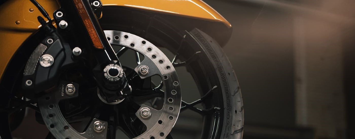 A close up shows the wheel on a yellow 2022 Harley-Davidson Road Glide Limited.