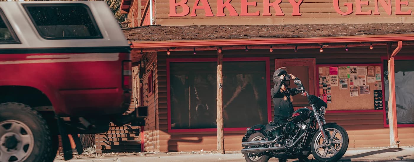 A black 2023 Harley-Davidson Softail Standard is shown parked in front of a bakery.